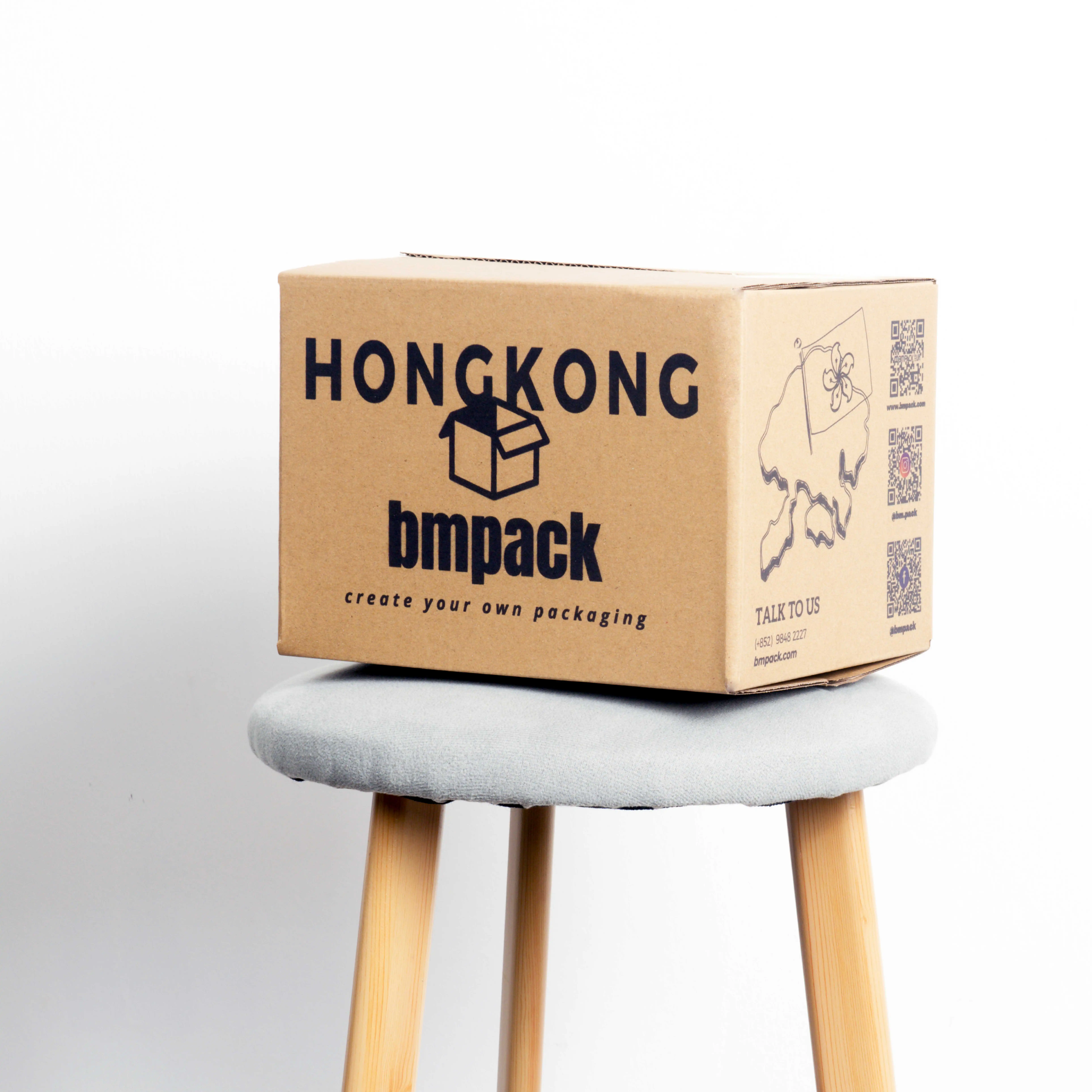 在一張圓凳上合上的紙箱, 印有“HONG KONG bmpack”